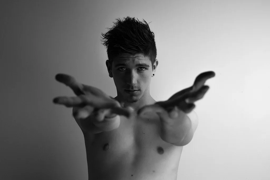Portrait en noir et blanc, bras tendus vers l’objectif.